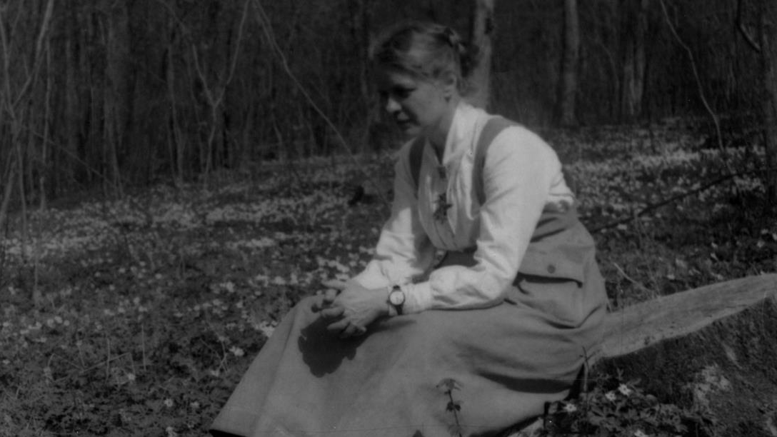 Elisabet Petersson, Göteborgs naturhistoriska museum, sittande bland vitsippor i Dalby hage utanför Lund. Bilden är tagen 28 april 1918.