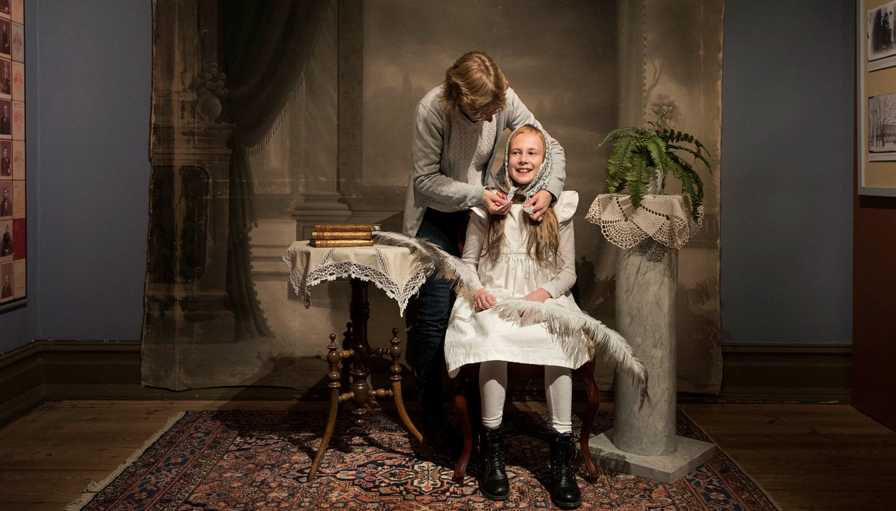 en flick får en ålderdomlig huvudbonad på sig