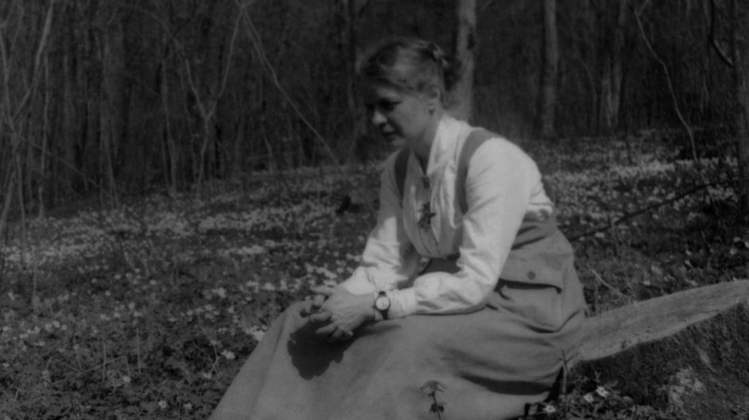 Elisabet Petersson, Göteborgs naturhistoriska museum, sittande bland vitsippor i Dalby hage utanför Lund. Bilden är tagen 28 april 1918.