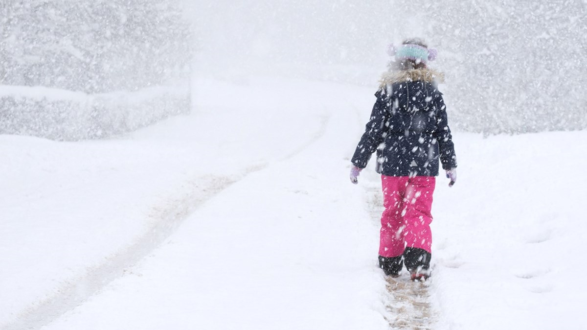 Flicka går i snölandskap